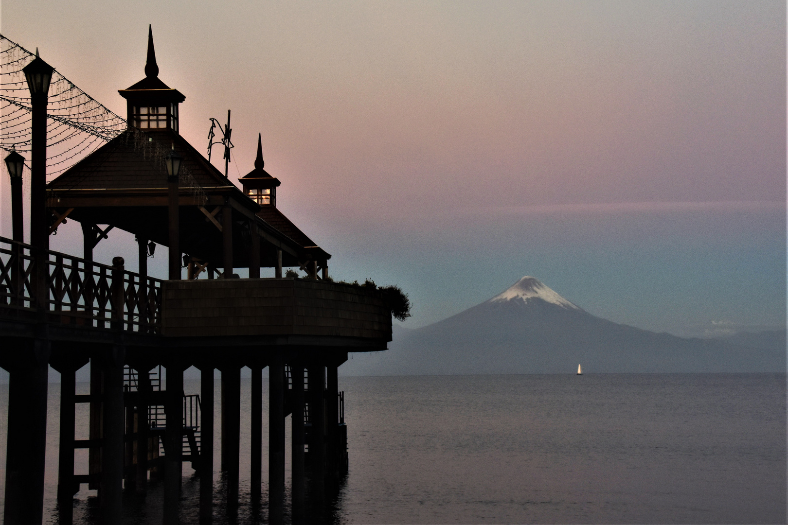 Ein Segelboot in der Abendstimmung vor dem Vulkan Osorno