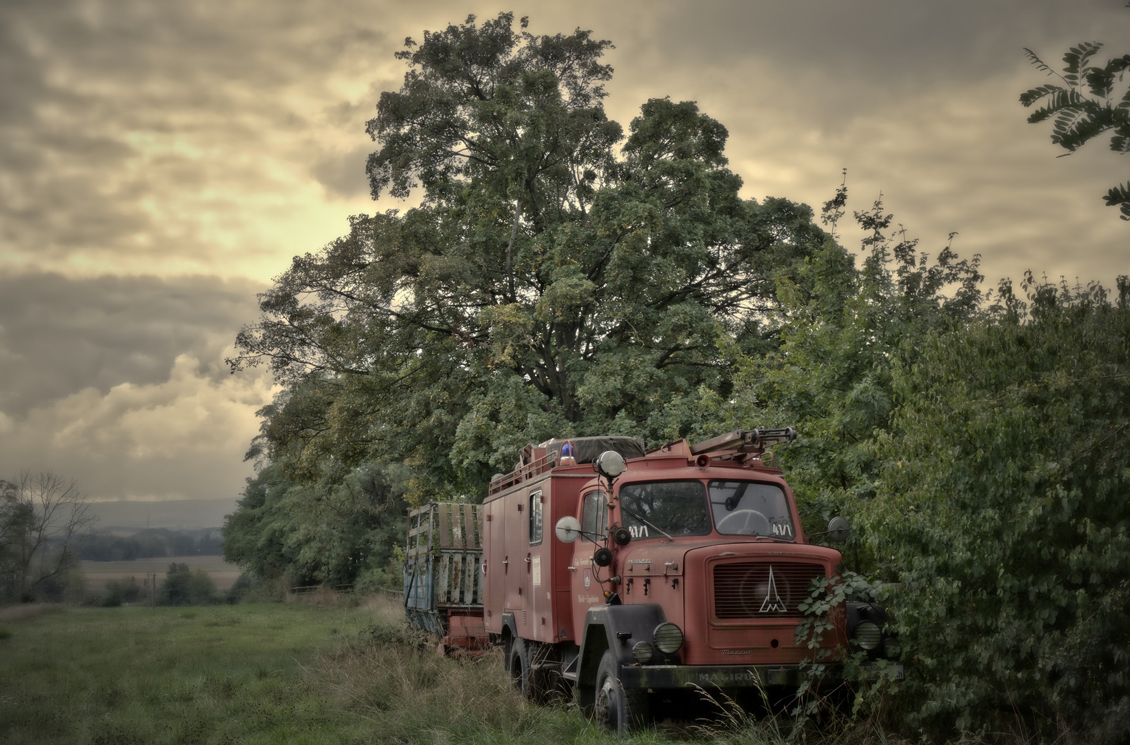 ein seltsames Gespann - altes Feuerwehrauto und Ladewagen auf grüner Wiese (1)