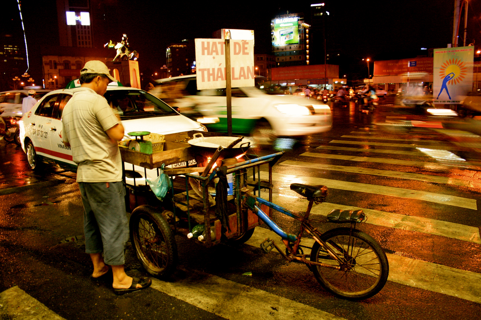 Ein Strassenverkäufer inmitten des Verkehrs von Saigon