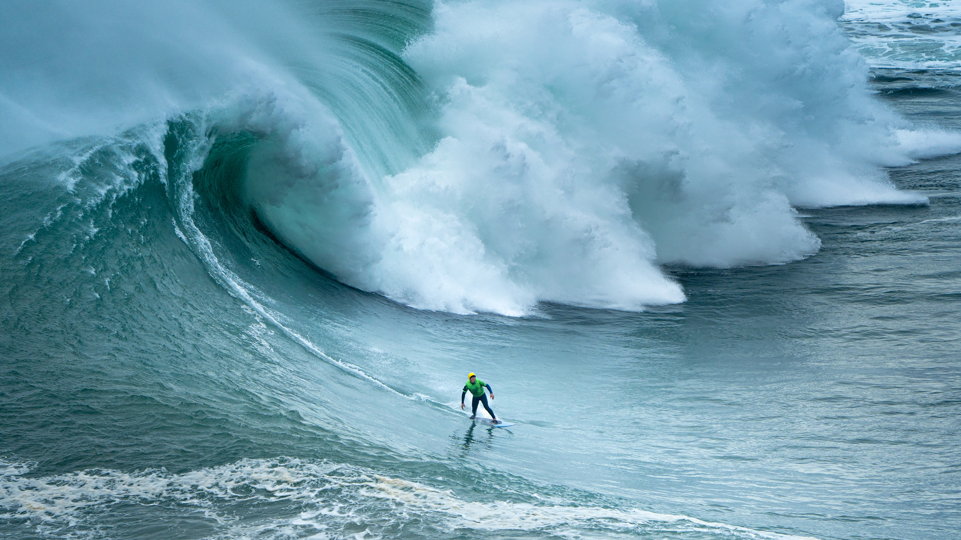 Ein Surfer in den Wellen von Nazaré in Portugal