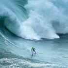 Ein Surfer in den Wellen von Nazaré in Portugal
