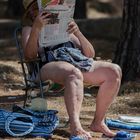 Ein Tag am Strand: Zeitungsleserin