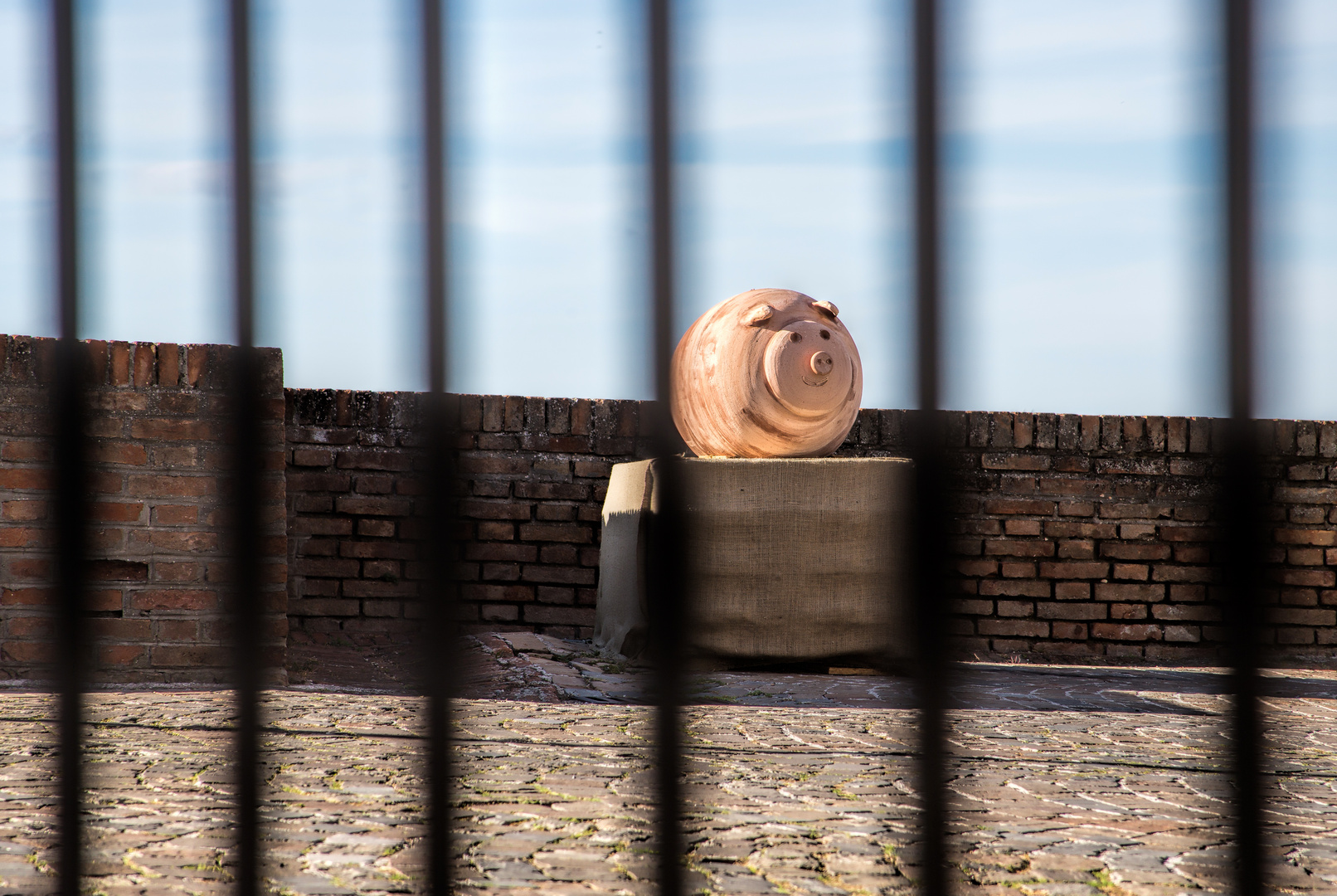 Ein Terracotta-'Schweinderl' hinter Gittern
