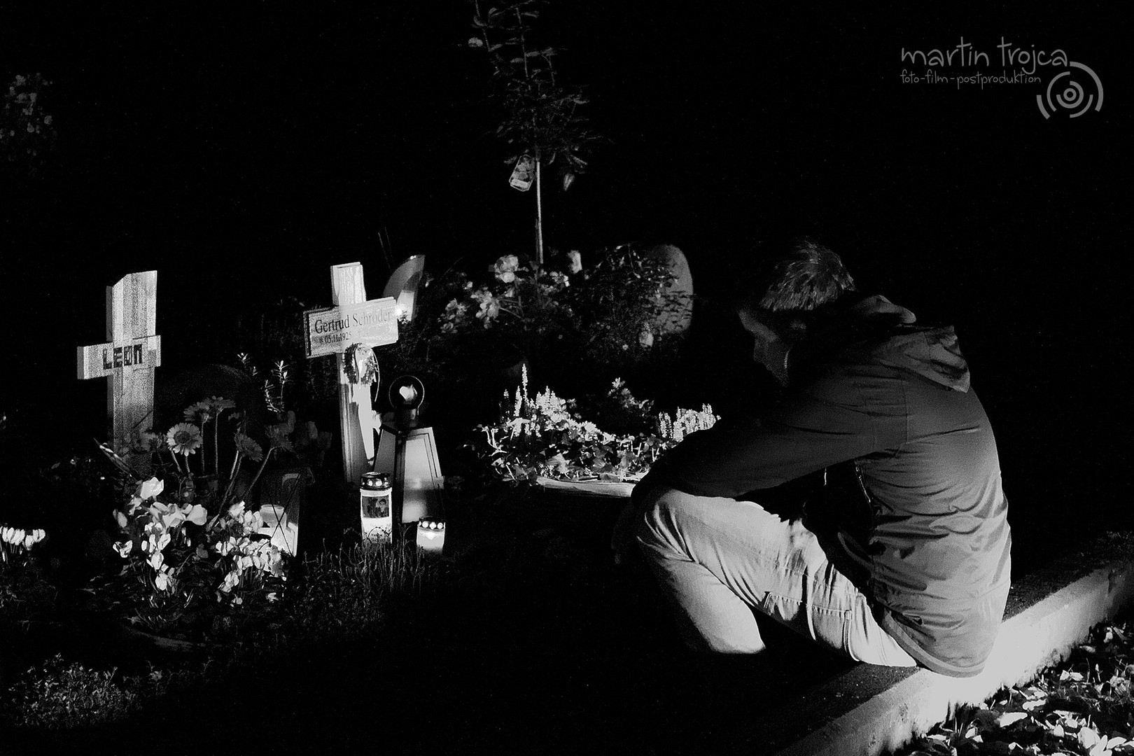 Ein trauernder Junge nachts auf einem Friedhof