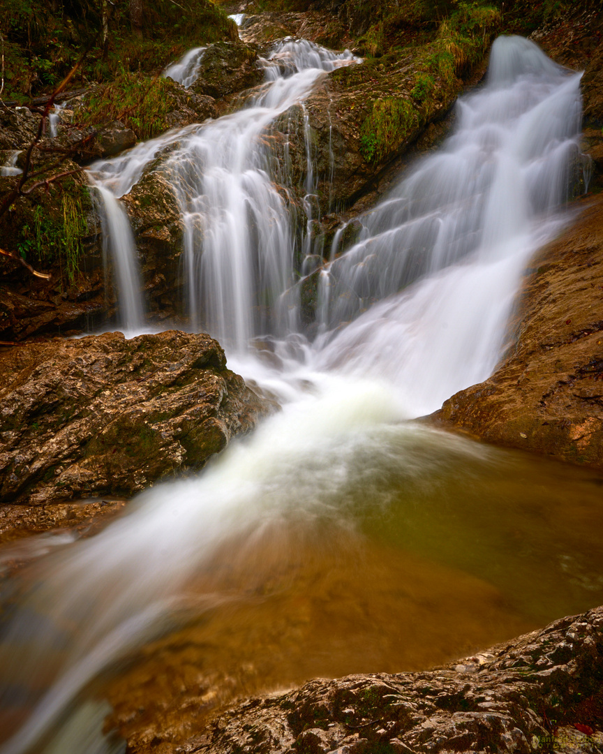 Ein versteckter Wasserfall mitten in einem dunklen Wald.