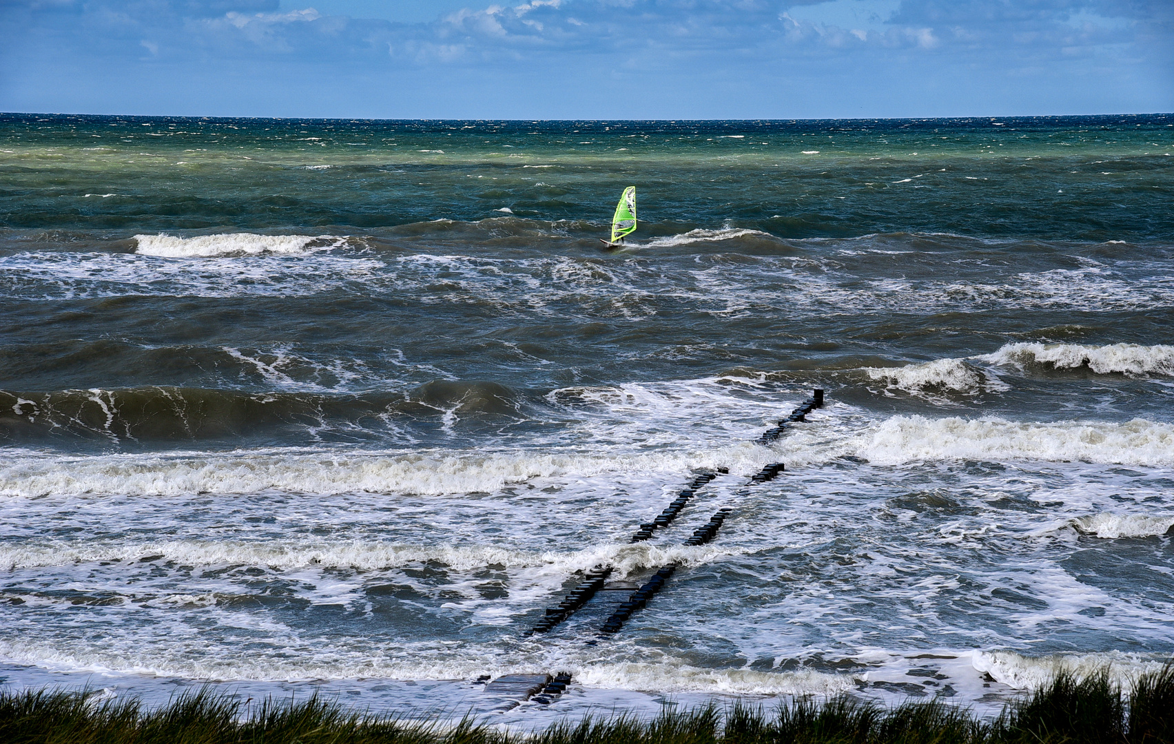 Ein Windsurfer segelte im Meer. 