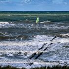 Ein Windsurfer segelte im Meer. 