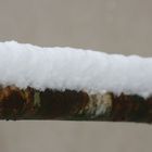 Eine alte Stange im Winter, bedeckt mit ein paar cm dickem Schnee