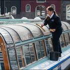 Eine Frau reinigt die Glasscheiben eines Ausflugbootes