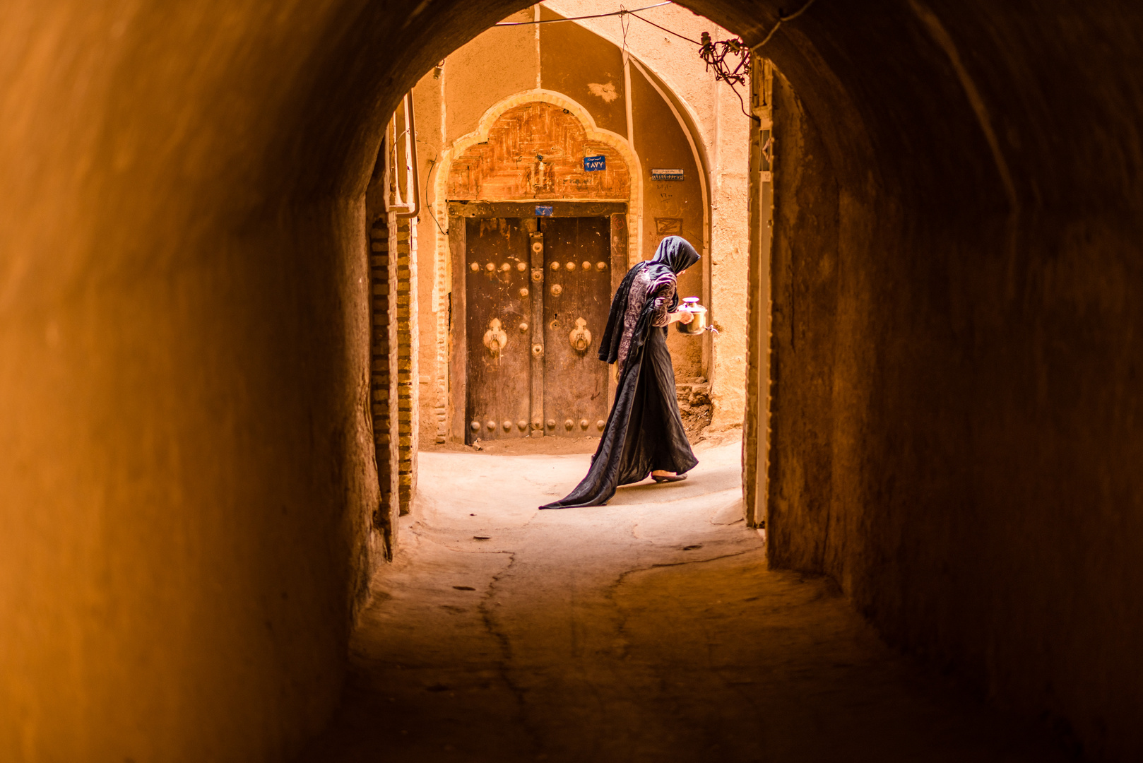 Eine Frau trägt Essen durch die Altstadt von Yazd