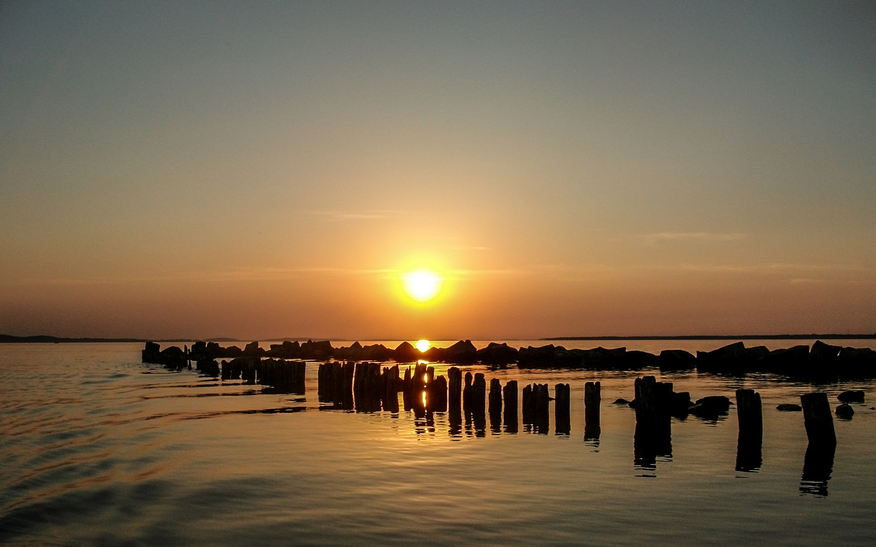 eine Hafeneinfahrt am großen Jasmunder Bodden mit beginnenden Sonnenuntergang