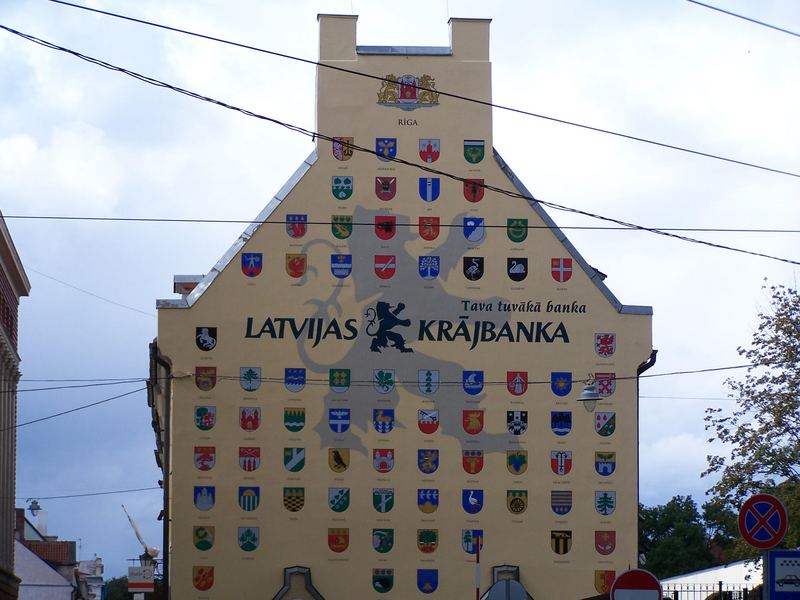 Eine Hauswand mit Städtewappen