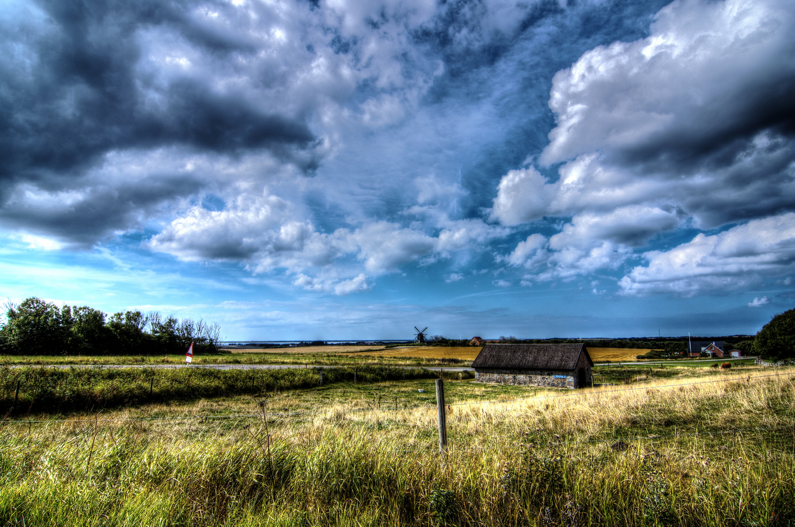 Eine kleine Mühle in der großen weiten Landschaft von Dänemark.