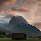 Eine leicht in Wolken eingehüllte Zugspitze bei Sonnenuntergang