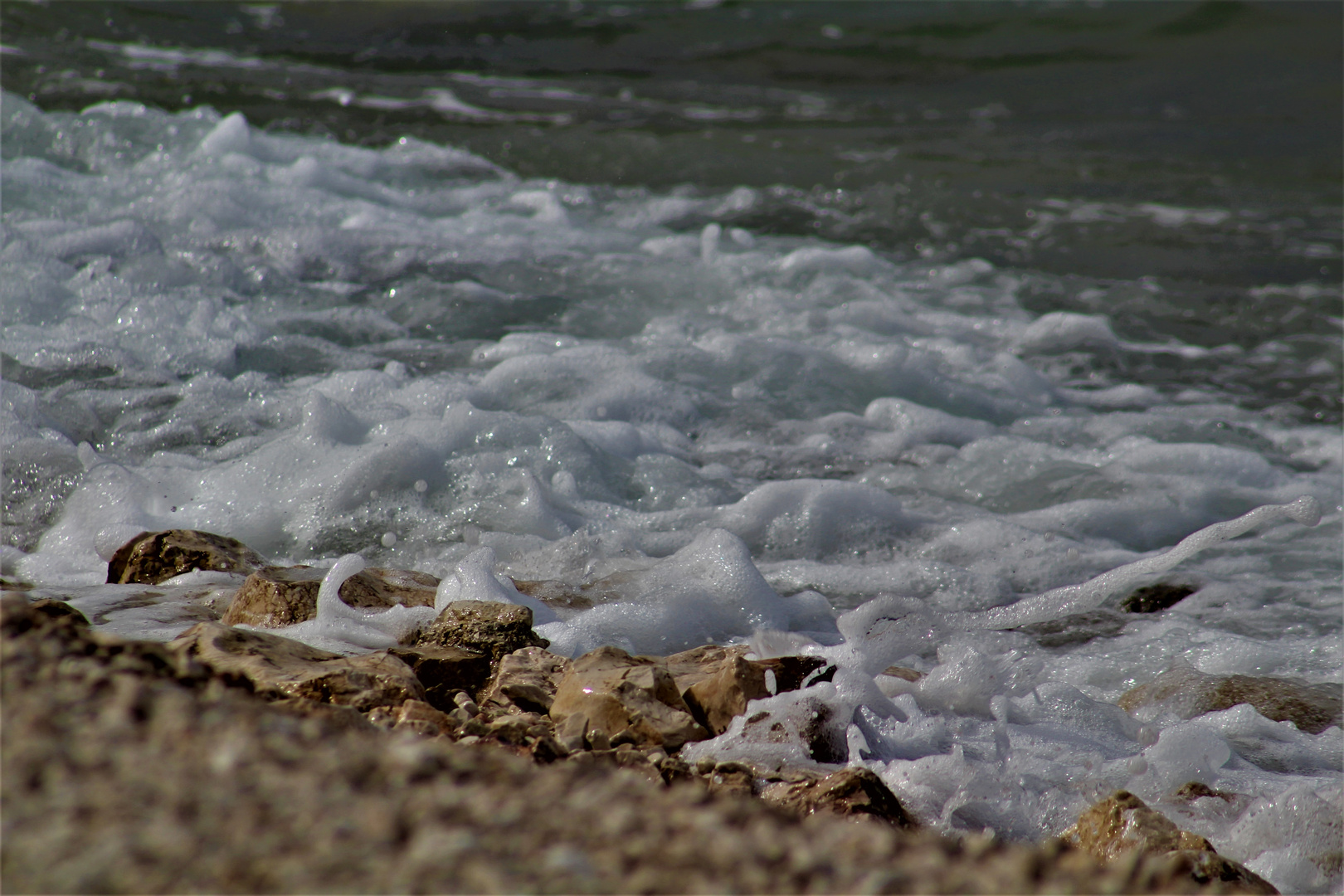 eine Welle schafft sich Raum  am Ufer