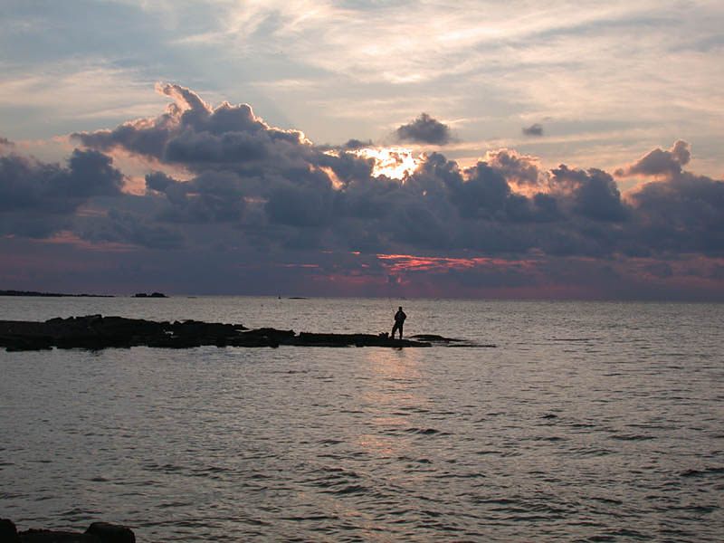 einsamer Angler bei Sonnenuntergang