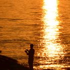 einsamer Angler bei Sonnenuntergang mitten im November