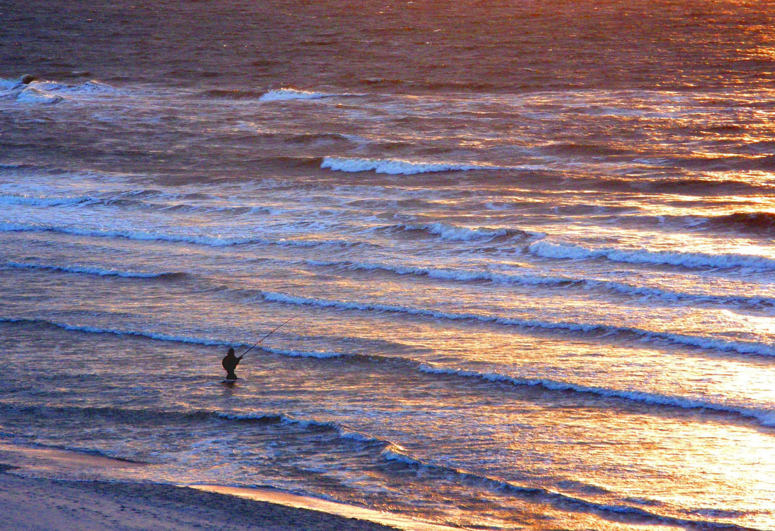 Einsamer Angler vor Sonnenuntergang