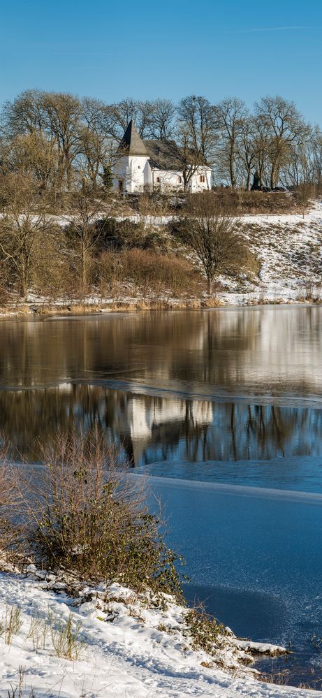 Eis und Wasserspiegelung der Martinskirche am Weinfelder Maar