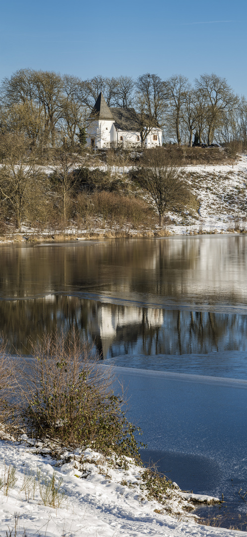 Eis und Wasserspiegelung der Martinskirche am Weinfelder Maar