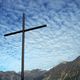 Eisen-Kreuz vor Wolkenhimmel ber der Adula-Gruppe