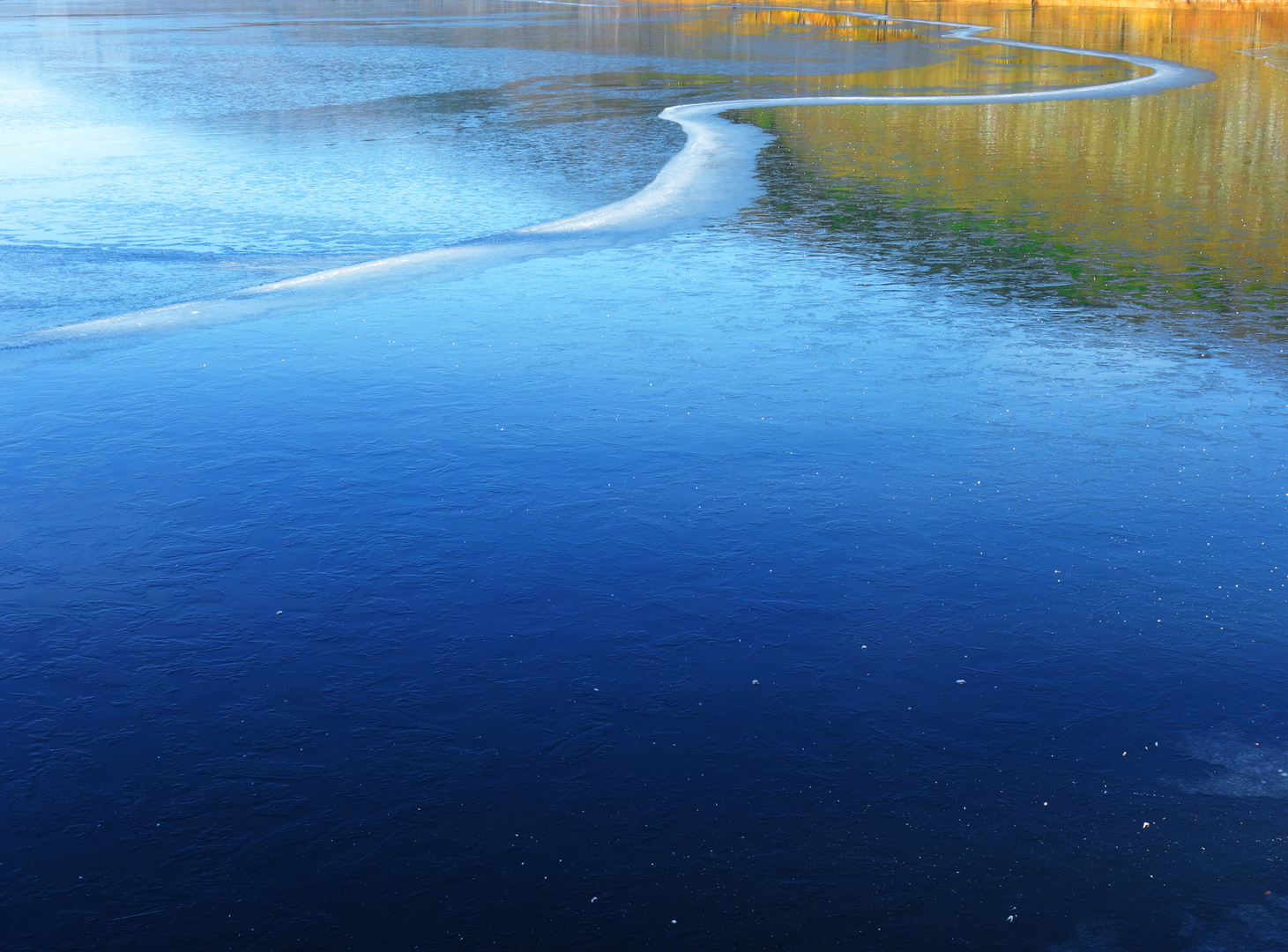 Eisfläche und Spiegelung eines Berges in der Sonne