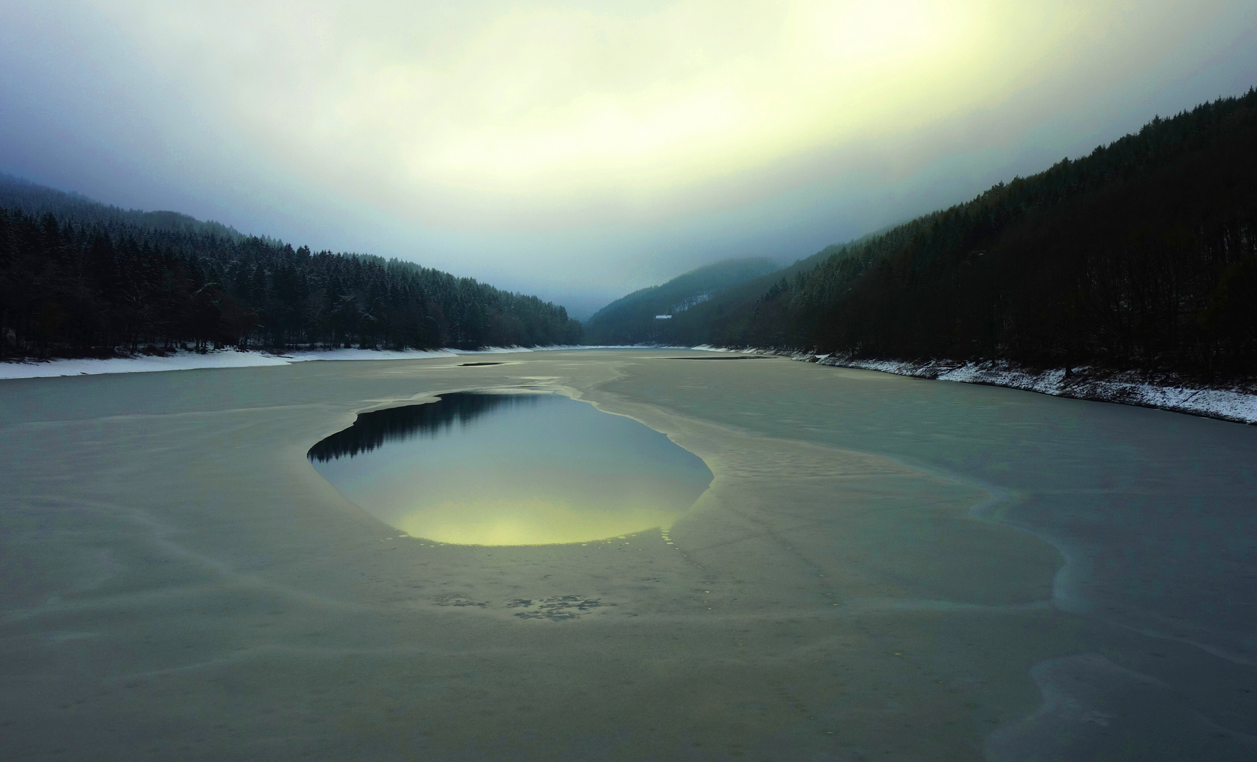 Eisloch im Schneematsch auf der Talsperre