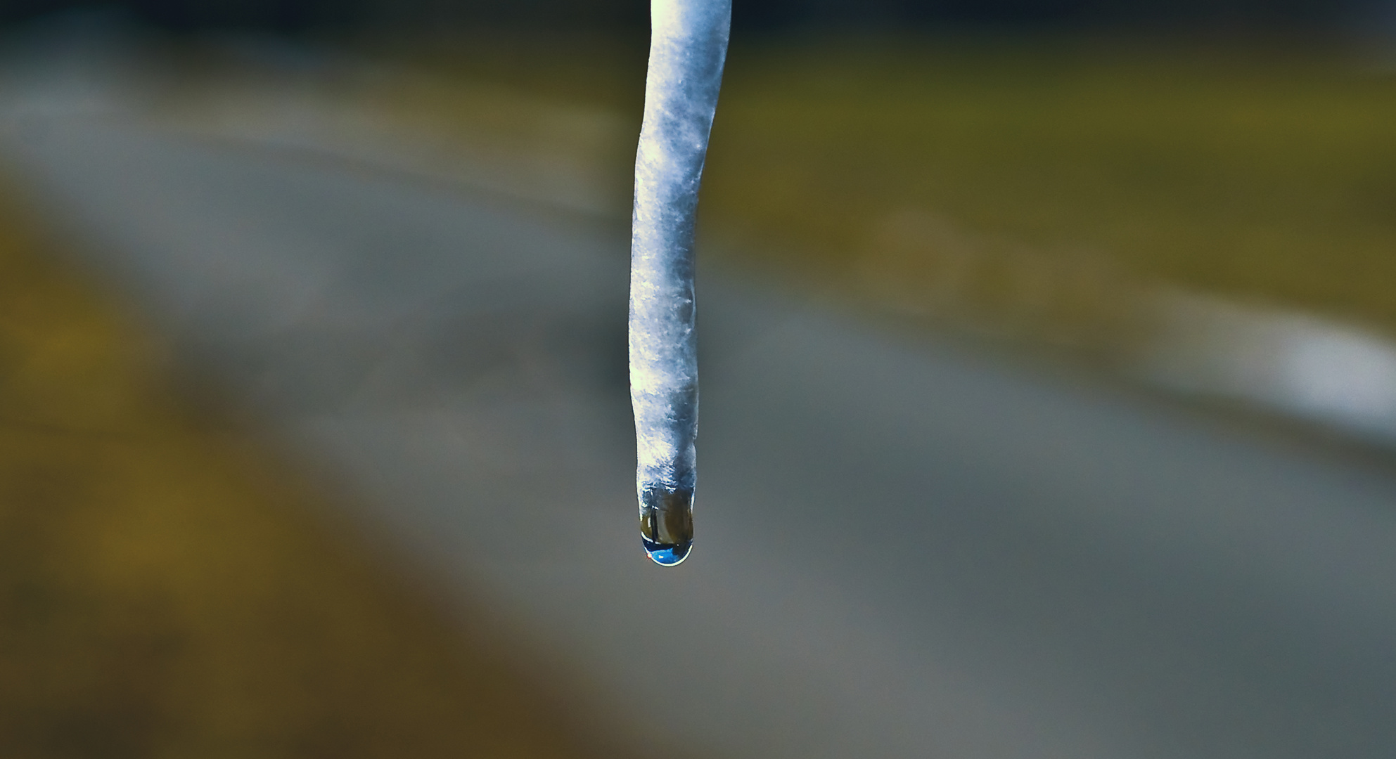 Eiszapfen mit einer Spiegelung vom Himmel und Sonne