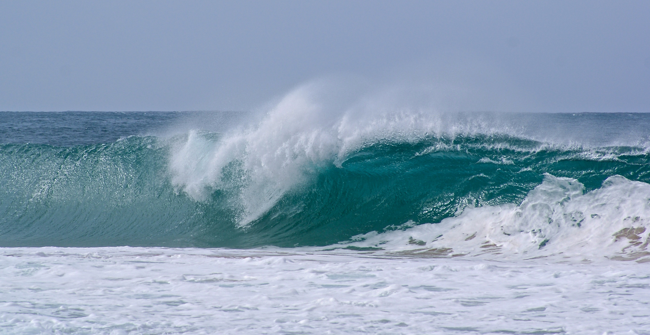 el mar, las olas y una tabla de surf