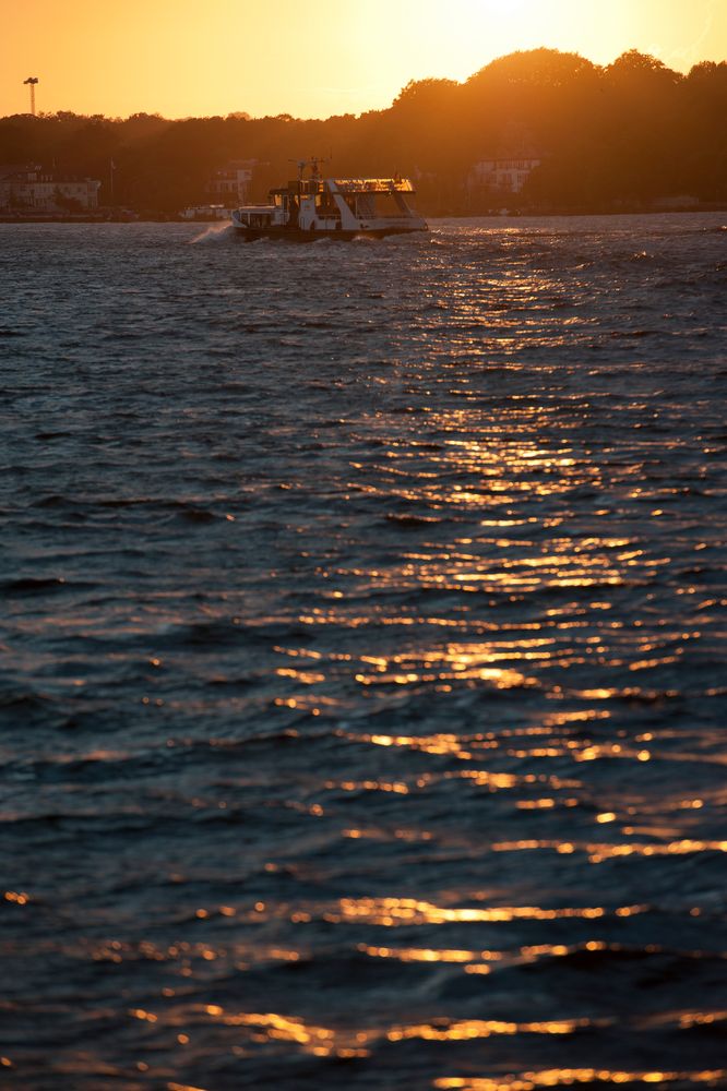 Elbe vor Hamburg bei Sonnenuntergang mit Schiff