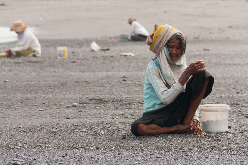 Elder women collecting black stones@East Bali, Indonesia