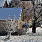 entlang an winterlichen Gärten und einem alten Steinhaus