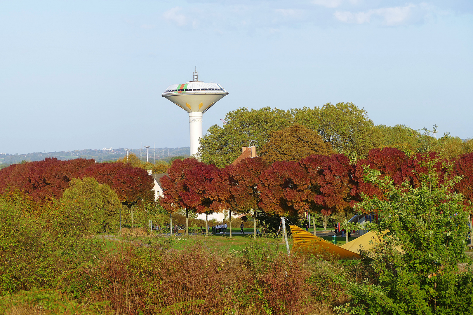 er ragt hinter den herbstlich gefärbten Bäumen hervor