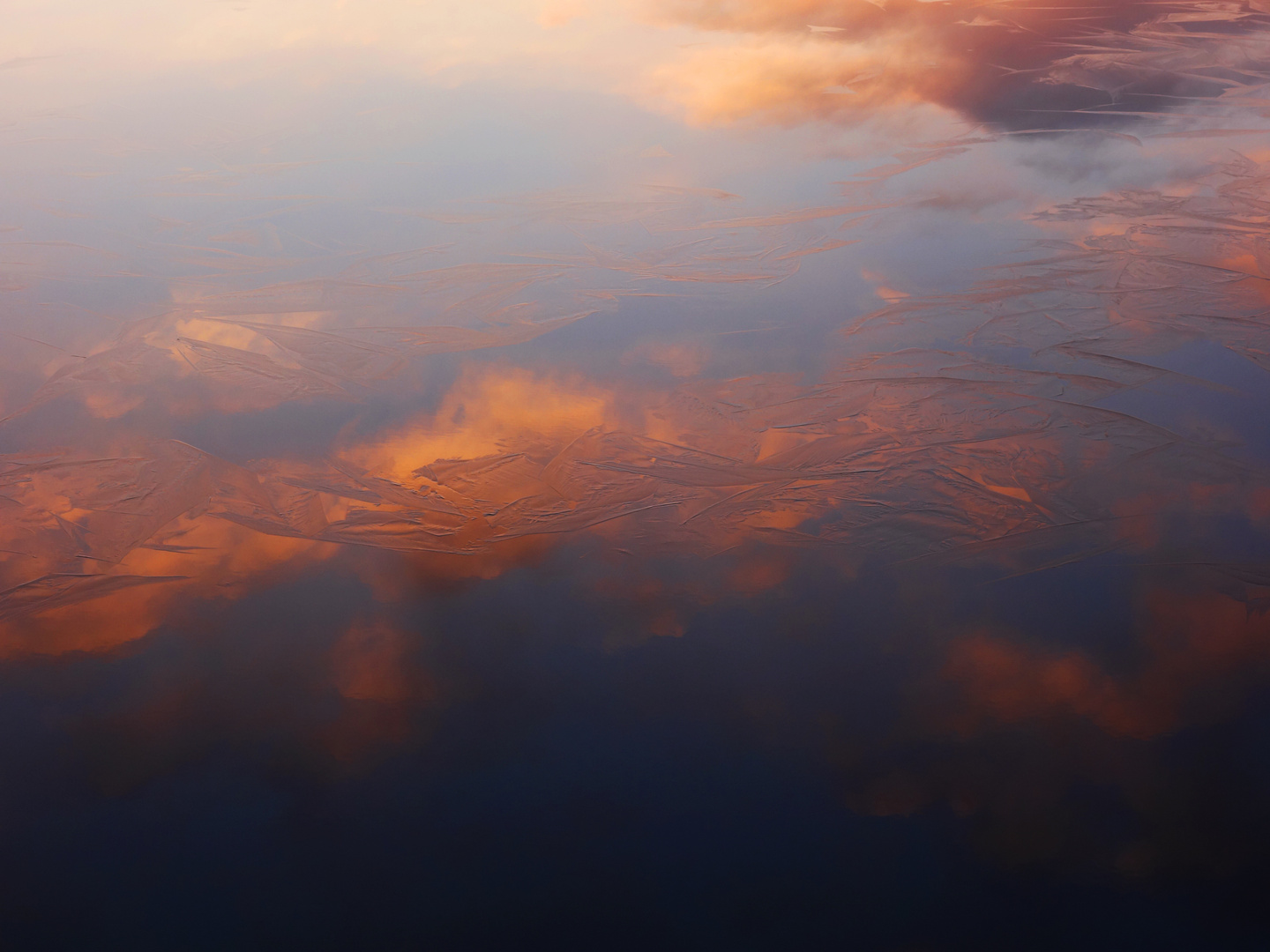 erste ganz zarte Eisschicht auf Sonnenuntergangsspiegelungen