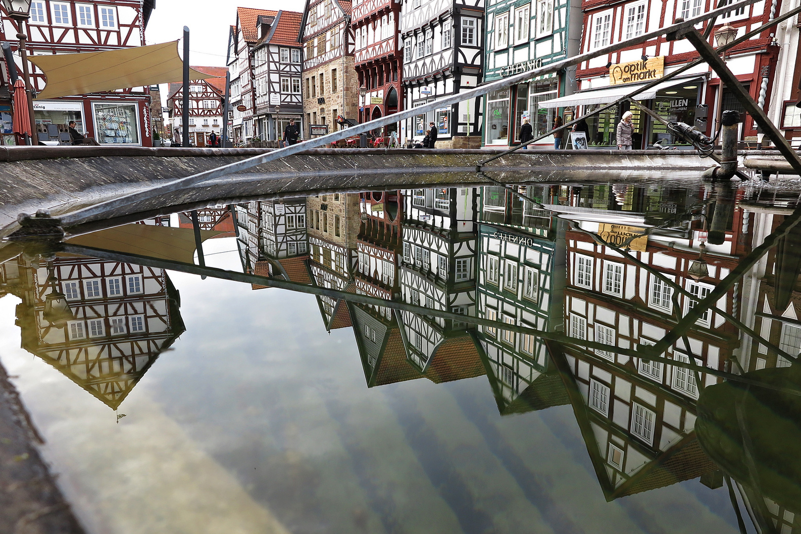 Fachwerkhäuser spiegeln sich im Brunnen am Marktplatz von Fritzlar