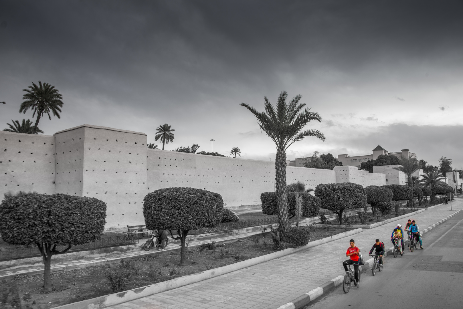 Fahrradfahrer vor der Stadtmauer zur Altstadt in Marrakech, Marokko