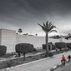 Fahrradfahrer vor der Stadtmauer zur Altstadt in Marrakech, Marokko