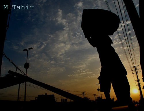 FAISALABAD: Labor busy in loading goods on truck. PHOTO by Muhammad Tahir