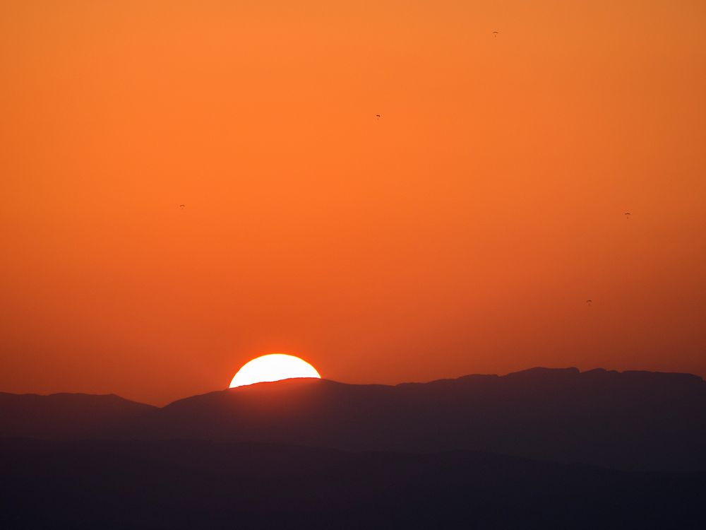Fallschirmsprung während des Sonnenunterganges