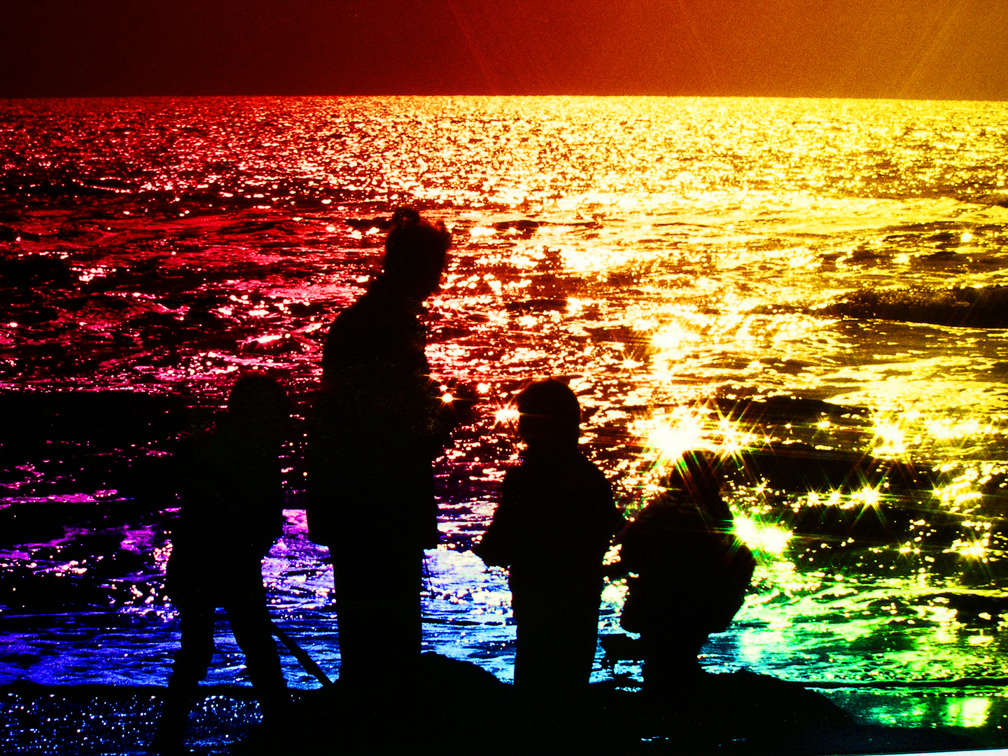 Familie beim Spielen an farbigem Meer