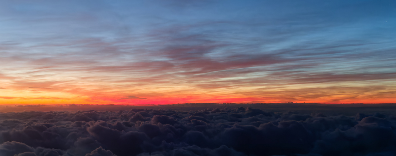 Farbenrausch bei Sonnenuntergang über den Wolken