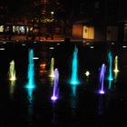 farblich beleuchteter Brunnen bei Nacht
