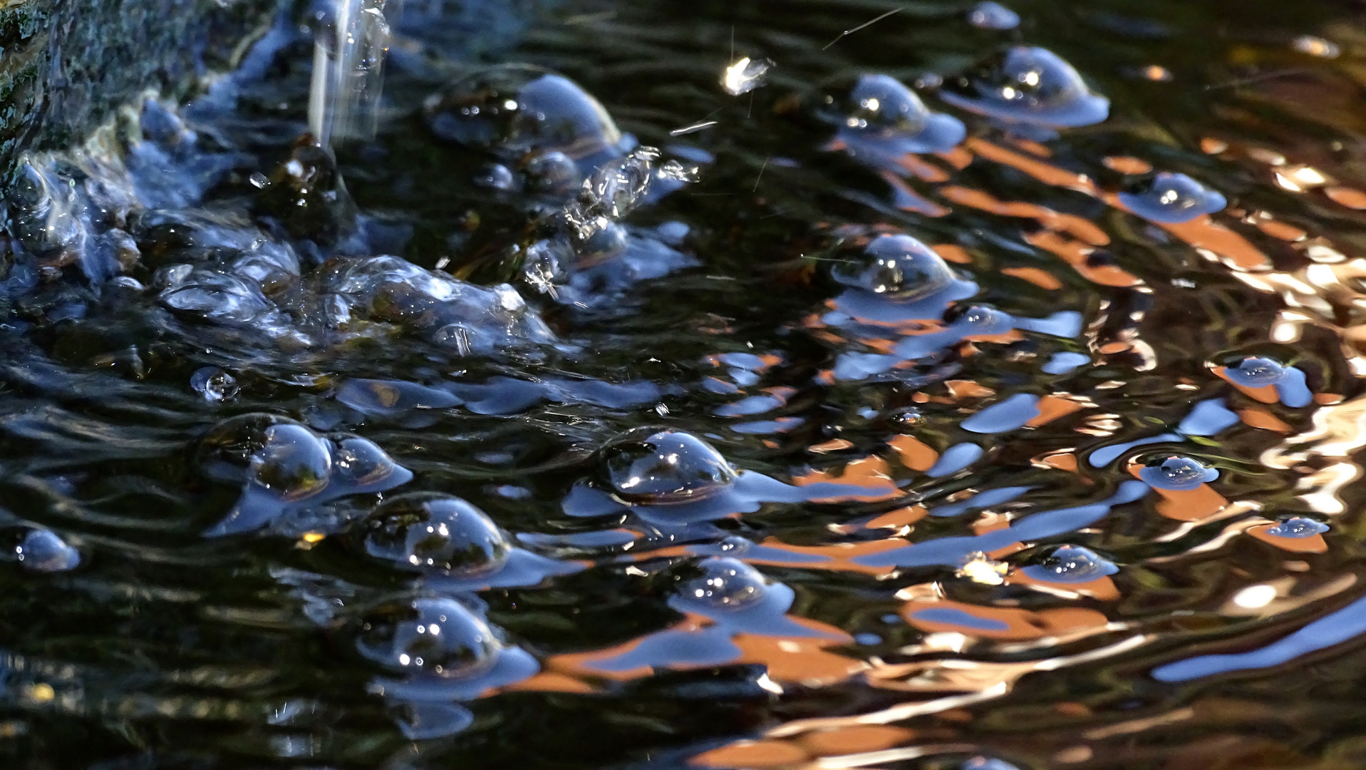 Farbluftblasen durch Wasserspiel im Brunnen