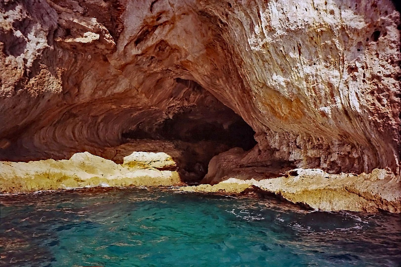 Farbspiel im Wasser vor einer Grotte