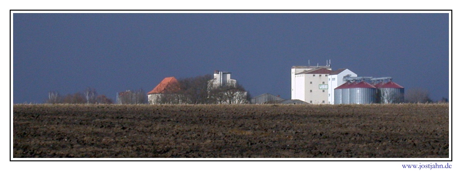 Farm buildings against storm clouds