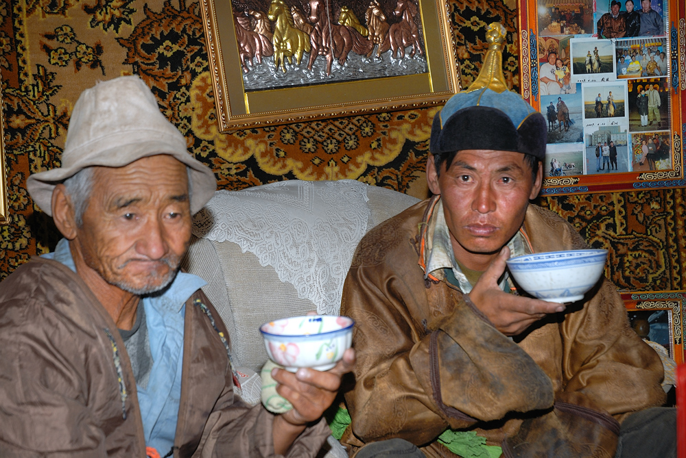 Father and son drinking tea with horse milk