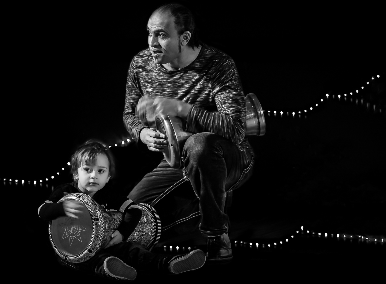 Father and son playing darbuka