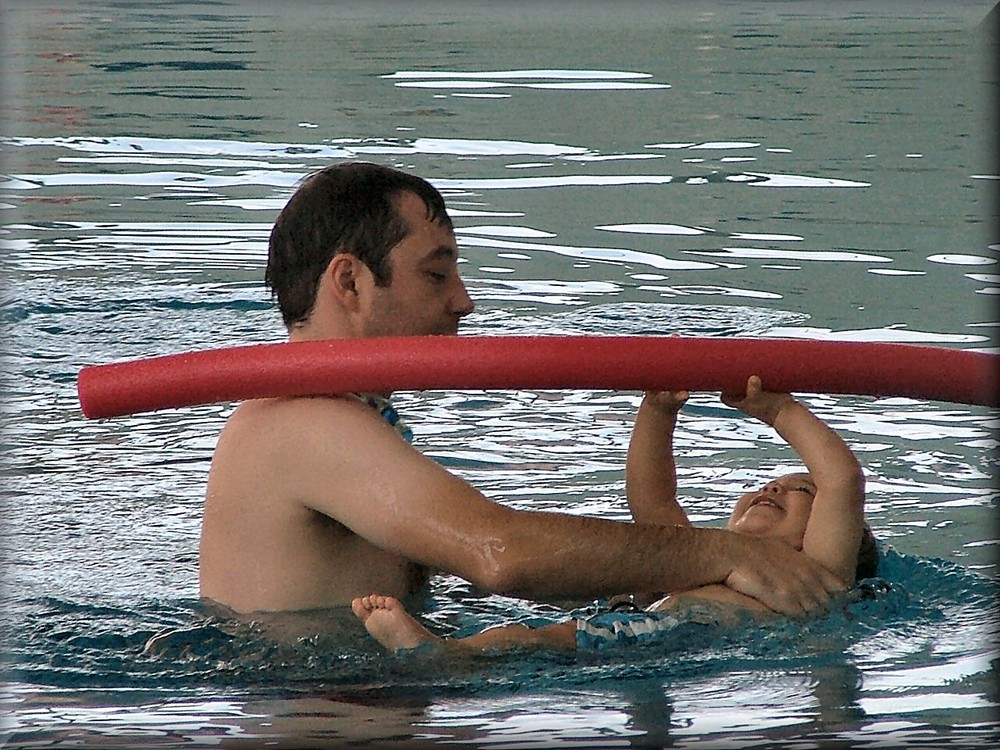 Father and son playing in swimming-pool.