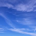 Feine weiße Federwolken am blauen Himmel.