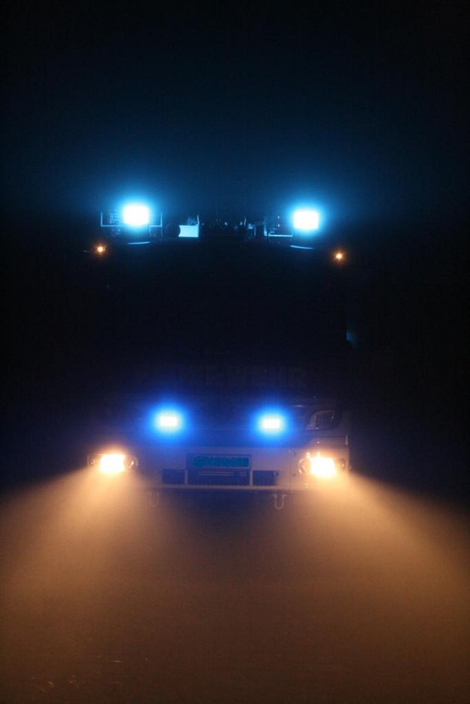 Feuerwehr HLF20/16 bei Nacht im Nebel mit Blaulicht